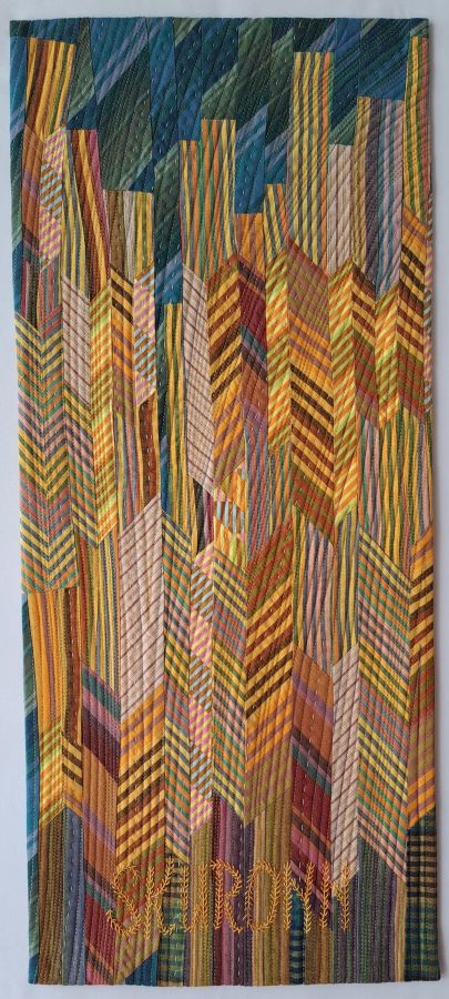 Abstract vertical striped fabric with orange, yellow, and blue tones, layered and overlapping in a textured pattern.
